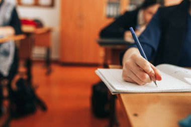 depositphotos_350388900-stock-photo-the-student-writes-in-a